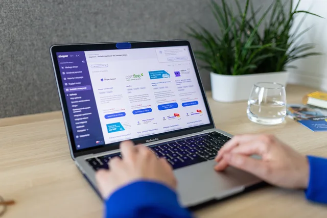 Close-up of hands on a laptop browsing an e-commerce site in a modern office. Eight shopping feeds AI applications worth planning for now