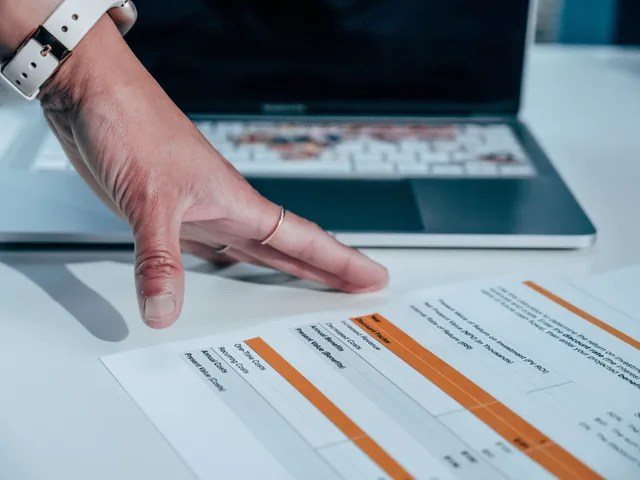 Close-up of a hand reviewing a financial report on a laptop, indicating focus on business analysis. What is the shopping feeds market size in England?